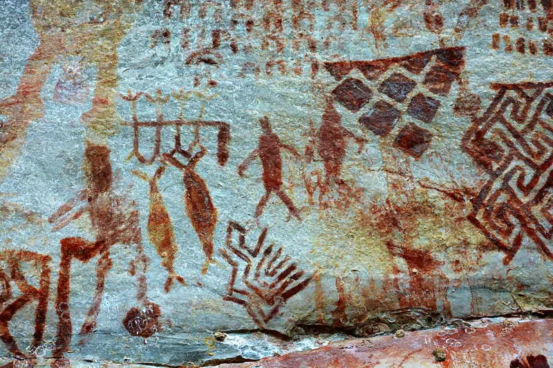 Hombres danzan con tronco-poste-rbol en la parte media de su cuerpo, dejando colgado un calabazo o un fruto en el lado derecho. Otras figuras humanas acompaan la escena con un nutrido nmero de geomtricos y una semilla de yopo con propulsor al lado de un bailarn. 