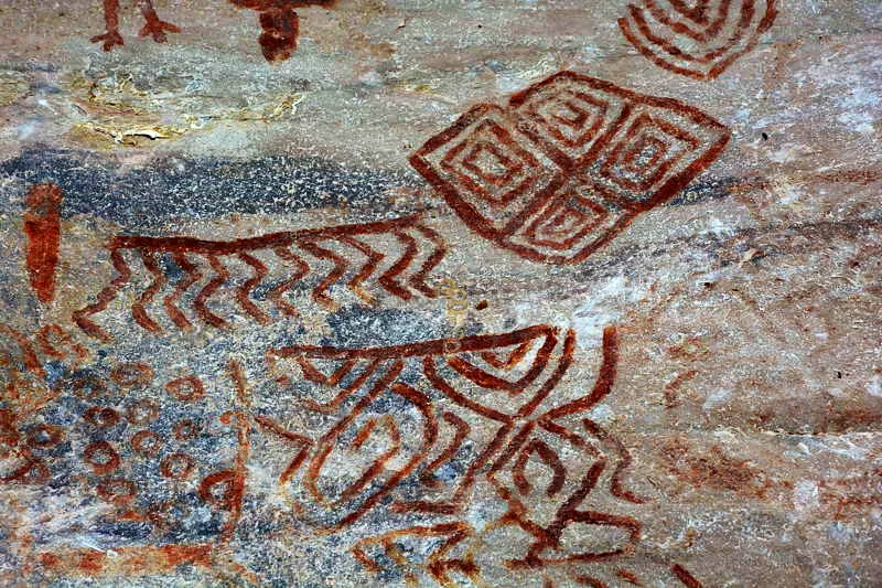 En las fases Guayabero/ Guaviare y Papamene se observan lneas ondulantes que representan los hombres danzantes con vara-poste sobre sus cabezas. En esta imagen, lnulas-rombos en racimo y una cuatriparticin geomtrica, as como crculos felinos, complementan la escena abstracta. 