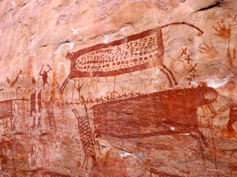 Sitio el Abrigo Falo del Caimn en el que se observa un felino en una lnula de Xs, acompaado de hombres bailando debajo de l, as como gran cantidad de hombres y otros animales a su alrededor. 