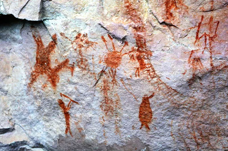 Hombres danzantes con un paquete de armas, en medio de ritual. 