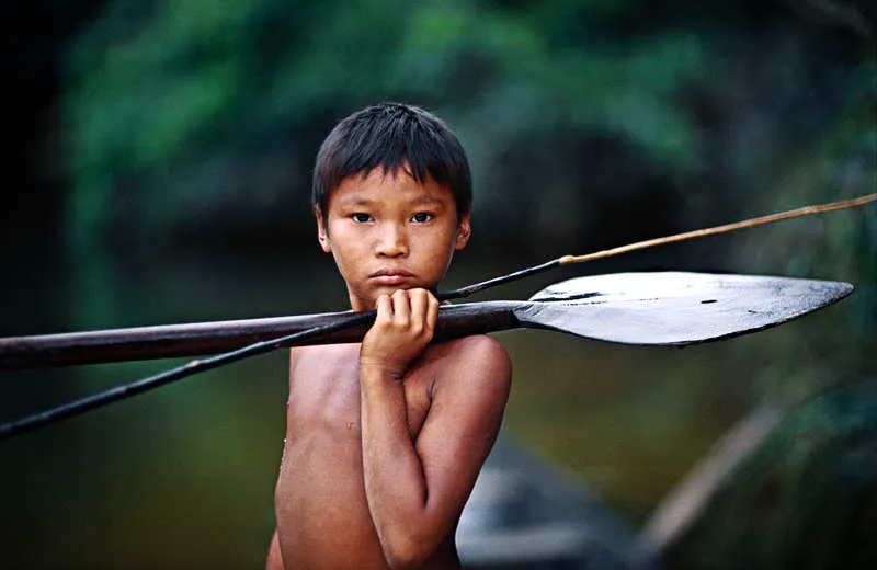 Un muchacho se alista para una faena de pesca, utilizando los aparejos que han sido consagrados por sus mayores, en medio del proceso de aprendizaje como cazador y guerrero antes del rito de iniciacin. 