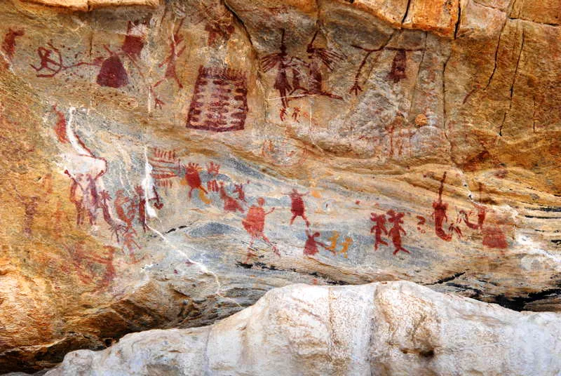 Escena del Abrigo Xique- Xique en Carnaba dos Dantas (regin de Serid) en que se aprecia una serie de elementos claves relacionados con la iconografa ritual y sagrada de Chiribiquete, como las ramas con panales o enjambres de avispas, que algunos hombres estn en faena de captura, posiblemente. Otra rama con panel se ubica al lado de una pareja de cabellos largos (ver representaciones sexuales de estos) con infante, que aparentemente forcejean, y entre estos dos paneles de avispas, una matriz, posiblemente codificada con pequeos hombres en patrn de baile. Siguiendo la iconografa de Chiribiquete, la pareja lleva sobre sus narices un cono de planta sagrada (posiblemente yopo). Debajo de la escena, varias parejas forcejean por infantes, algunas con actitud hostil. Varias representaciones humanas en agitacin, al lado de un hombre con corona, junto a una parrilla. Ms a la derecha, un hombre planta-lnula deja un rastro de elongacin al lado de dos bicfalos con cabeza de C. 